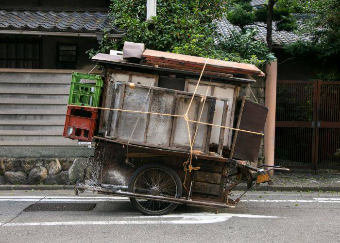 An old-timey yatai food stall with tables and stools tied onto the stall with cables.